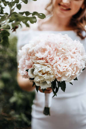Girl bride holding a wedding bouquet of flowersの写真素材