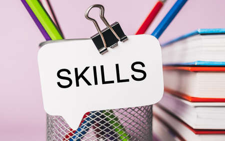 Text SKILLS on a white sticker with office stationery background. Flat lay on business, finance and development conceptの写真素材