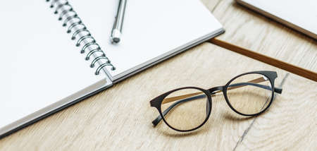 Glasses at the workplace in the office near the laptop and notepad. Business hoursの写真素材