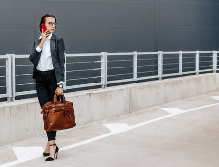 A business woman checks the time in the city during a working day waiting for a meeting. Discipline and timing. An employee goes towards a corporate meeting.の写真素材