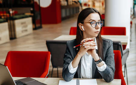 Girl works on a laptop in the workplace. Successful business woman creates a startup and makes decisions.の写真素材