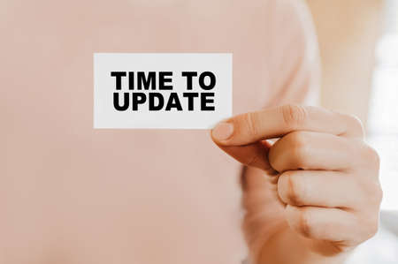 Man holding a business card with Time to updateの写真素材