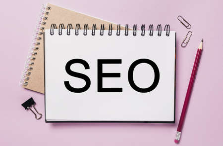 Text seo on a white sticker with office stationery background. Flat lay on business, finance and development conceptの写真素材