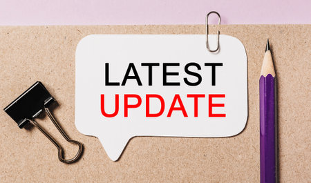 Text Latest Update on a white sticker with office stationery background. Flat lay on business, finance and development conceptの写真素材