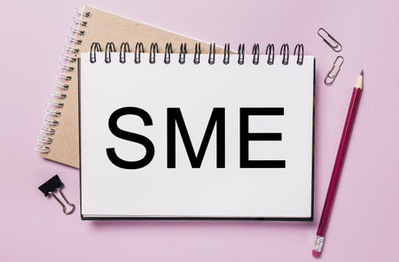Text sme on a white sticker with office stationery background. Flat lay on business, finance and development conceptの写真素材
