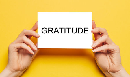 Female hands hold card paper with text Gratitude on a yellow background. Business and finance conceptの写真素材