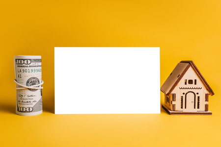 House miniature model and money with blank background on a yellow background. Investment, real estate, home, housingの写真素材