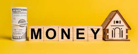 MONEY with house miniature model and money on a yellow background. The concept of business, finance, credit, tax , real estate, home, housingの写真素材