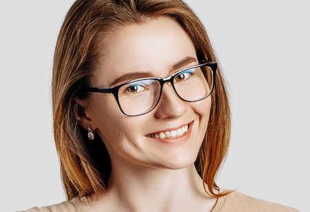 Beautiful young business woman wearing glasses isolated on gray background. Achieving career wealth business concept.の写真素材
