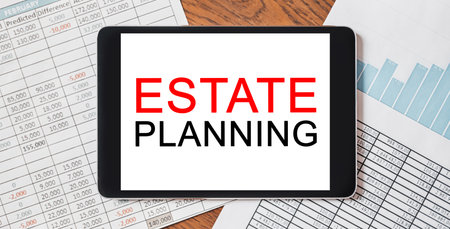 Tablet with text Estate Planning on your desktop with documents, reports and graphs. Business and finance conceptの写真素材