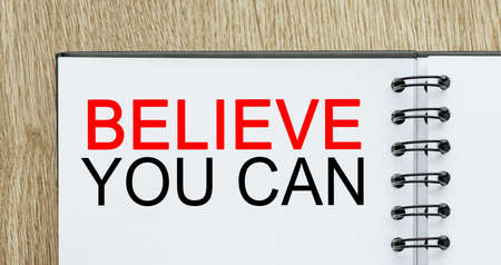 Notepad with text Believe you can on wooden deskt. Business and finance conceptの写真素材