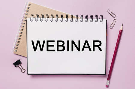 Text webinar on a white sticker with office stationery background. Flat lay on business, finance and development conceptの写真素材