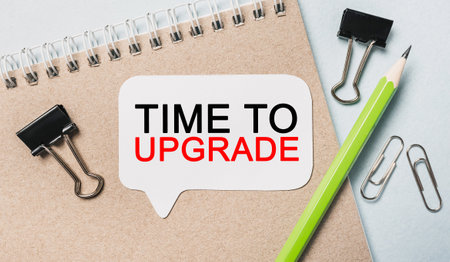 Text Time to upgrade on a white sticker with office stationery background. Flat lay on business, finance and development conceptの写真素材