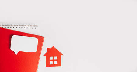 Sweet home. Estimating and paying house tax. Mock up with red house, notepad and sticker in copy space white backgroundの写真素材