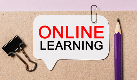Text online learning on a white sticker with office stationery background. Flat lay on business, finance and development conceptの写真素材