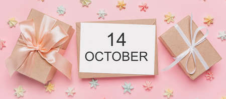 Gifts with note letter on isolated pink background with sweets, love and valentine concept with text 14 Octoberの写真素材