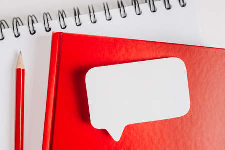 Red notepad and white sticker on the desk. Mock up in copy space office background. It is important not to forget the noteの写真素材