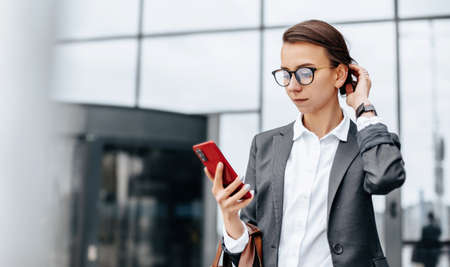 A business woman checks the time in the city during a working day waiting for a meeting. Discipline and timing. An employee goes towards a corporate meeting.の写真素材