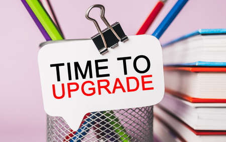Text Time to upgrade on a white sticker with office stationery background. Flat lay on business, finance and development conceptの写真素材