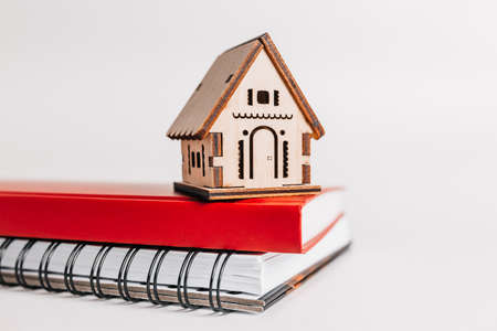 Sweet home. Estimating and paying house tax. Mock up with red house, notepad and sticker in copy space white backgroundの写真素材