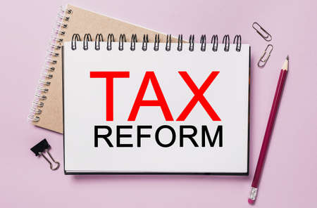 Text tax reform on a white sticker with office stationery background. Flat lay on business, finance and development conceptの写真素材