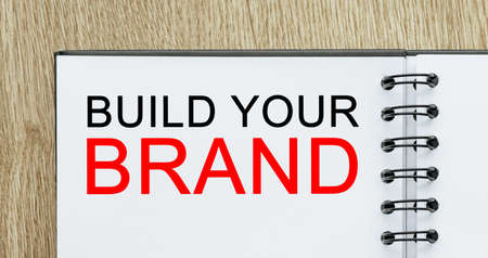 Notepad with text Build Your Brand on wooden deskt. Business and finance conceptの写真素材