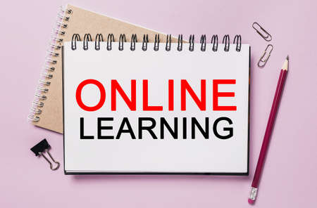 Text online learning on a white sticker with office stationery background. Flat lay on business, finance and development conceptの写真素材