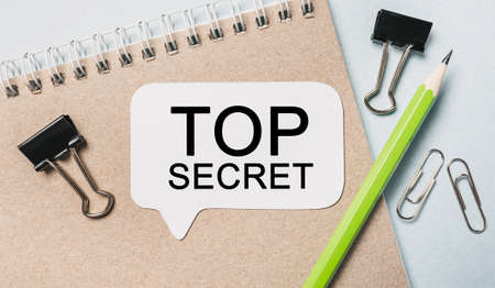 Text Top Secret on a white sticker with office stationery background. Flat lay on business, finance and development conceptの写真素材