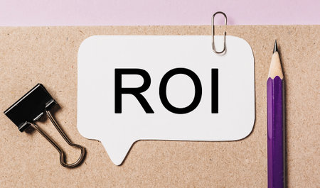 Text ROI on a white sticker with office stationery background. Flat lay on business, finance and development conceptの写真素材