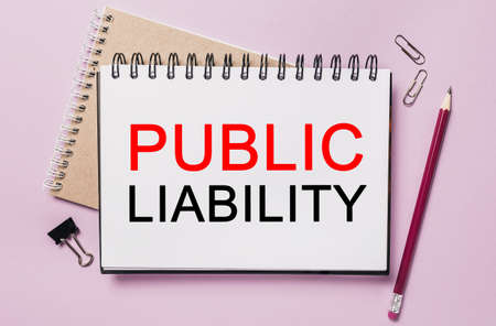 Text PUBLIC LIABILITY on a white sticker with office stationery background. Flat lay on business, finance and development conceptの写真素材