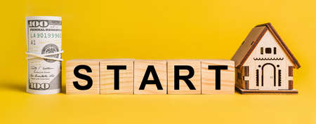START with house miniature model and money on a yellow background. The concept of business, finance, credit, tax , real estate, home, housingの写真素材