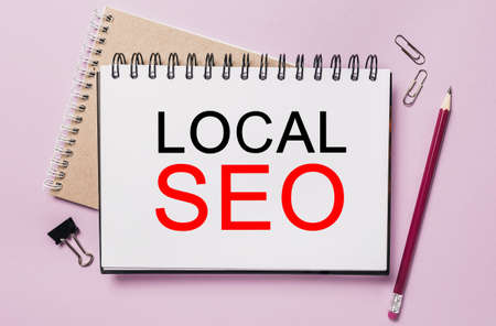 Text LOCAL SEO a white sticker with office stationery background. Flat lay on business, finance and development conceptの写真素材