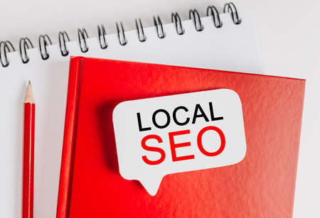 Text LOCAL SEO a white sticker with office stationery background. Flat lay on business, finance and development conceptの写真素材