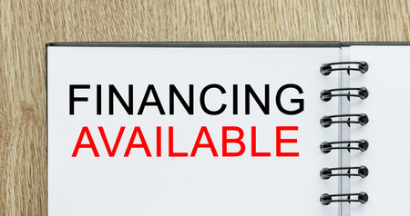 Notepad with text Financing Available on wooden deskt. Business and finance conceptの写真素材
