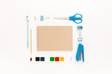 Top view of modern white blue office desktop with school supplies and stationery on table around empty space for text. Back to school concept flat lay with mockupの写真素材