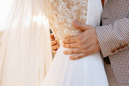 Bride and groom on wedding day hug and show love at sunset