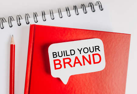 Text Build Your Brand on a white sticker with office stationery background. Flat lay on business, finance and development conceptの写真素材