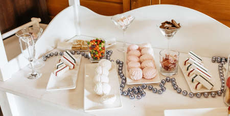 Candy bar at the banquet. Wedding table with sweets, cake, pastries, muffins, sugar treats. Event in the restaurantの写真素材