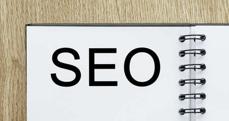 Notepad with text seo on wooden deskt. Business and finance conceptの写真素材