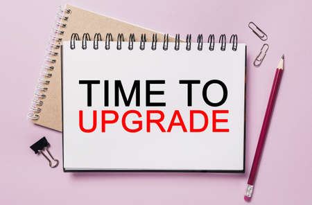 Text Time to upgrade on a white sticker with office stationery background. Flat lay on business, finance and development conceptの写真素材