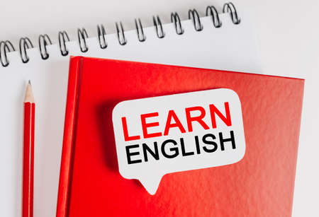 Text Learn ENGLISH on a white sticker with office stationery background. Flat lay on business, finance and development conceptの写真素材