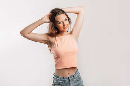 Beautiful young girl smiling and posing looking at the camera on a white isolated background. Positive brunette woman. Kind look. Beauty face.の写真素材