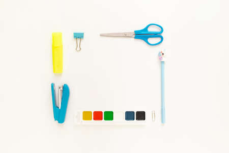 Top view of modern white blue office desktop with school supplies and stationery on table around empty space for text. Back to school concept flat lay with mockupの写真素材