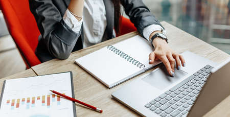 Girl works on a laptop in the workplace. Successful business woman creates a startup and makes decisions.の写真素材