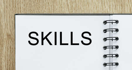 Notepad with text SKILLS on wooden deskt. Business and finance conceptの写真素材