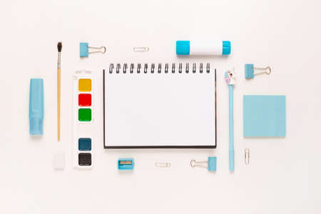 Top view of modern white blue office desktop with school supplies and stationery on table around empty space for text. Back to school concept flat lay with mockupの写真素材