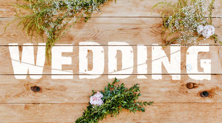 Text wedding on light wood decorated with plants and flowers. Wooden texture background mockup backgroundの写真素材
