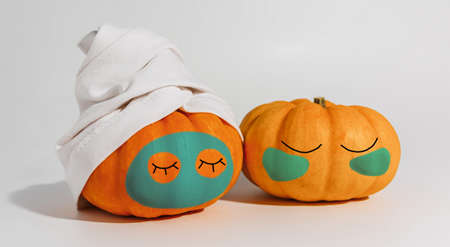 Pumpkin with facial mask and towel isolated on white background. Space for text mockup Spa and Halloween conceptの写真素材
