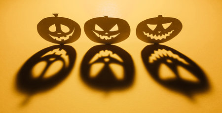 Halloween background concept. Jack O pumpkin angry face shadow. Spooky smiling shadow of an orange pumpkin lantern top view close up, Halloween party designの写真素材