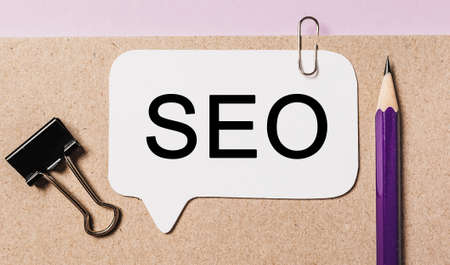 Text seo on a white sticker with office stationery background. Flat lay on business, finance and development conceptの写真素材